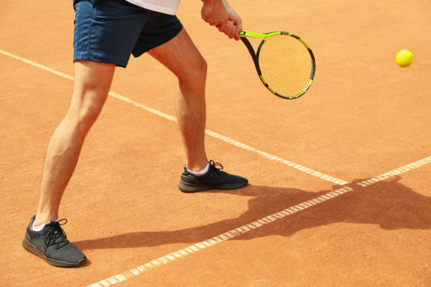 istock Young man playing tennis on clay court 1269375623