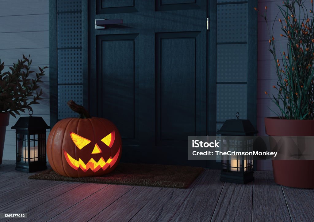 Jack o' Lantern in Front of Door High resolution digital image of a Jack o' Lantern sitting on a mat, on the front porch of  a residence, next to the door. Plenty of text space. Halloween Stock Photo