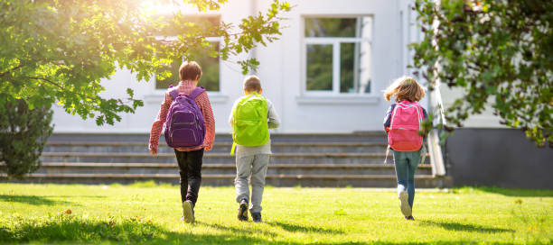 istock Children with rucksacks standing in the park near school 1269385175