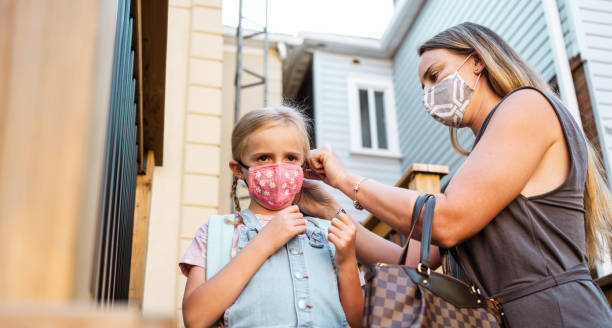 istock Mother and Daughter getting face masks on 1269385376