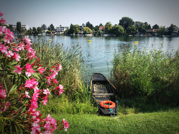 Idyllic river banks of Danube river at Alte Donau in Vienna, Austria, with a small boat