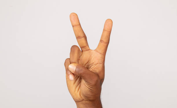 istock Black male hand making peace sign front of white background. 1269394738