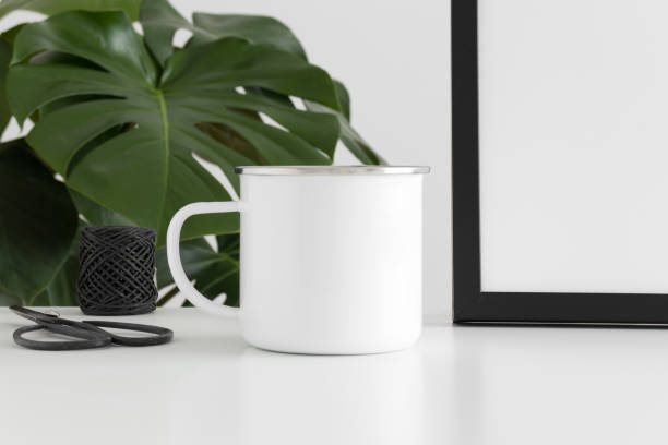 istock Enamel mug mockup with workspace accessories and a monstera plant. 1269394774