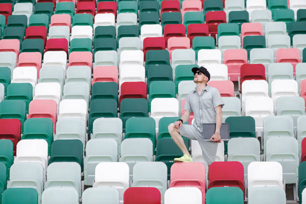 istock journalist on an empty sports field with a laptop 1269395128