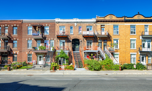 A row of similar old brick homes along a neighborhood street in Astoria Queens of New York City