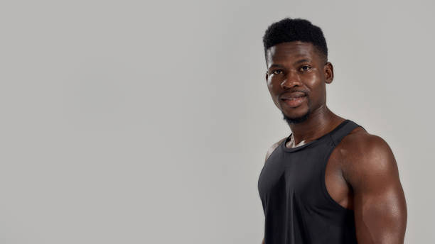 istock Young muscular african american man looking at camera, while posing isolated over grey background. Sports, workout, bodybuilding concept 1269396402