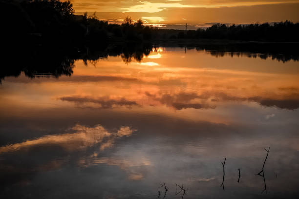 istock Summer colorful sunset at the lake with clouds reflected in water 1269396589