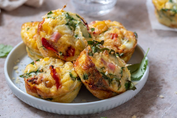 Delicious egg muffins with ham, cheese and vegetables Delicious egg muffins with ham, cheese, spinach and vegetables muffin stock pictures, royalty-free photos & images
