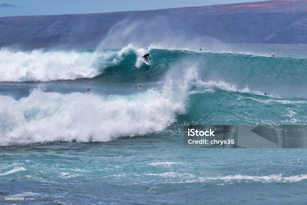 Lone surfer on a big wave on Maui. Very popular surf spot named "Dumps" on the south side of Maui with one surfer on a large wave. Surfing Stock Photo