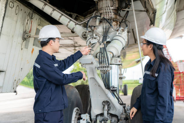 Asian man and woman engineer maintenance airplane team repairs, fixes, modernization and renovation in front airplane from  in airport. Asian man and woman engineer maintenance airplane team repairs, fixes, modernization and renovation in front airplane from  in airport. airplane maintenance stock pictures, royalty-free photos & images