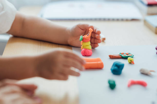 Hands of an Anonymous Girl Making Plasticine Figurines, Art and Craft Concept Homeschooling: cute preschooler making clay animals during an art lesson at home. clay sculpture stock pictures, royalty-free photos & images
