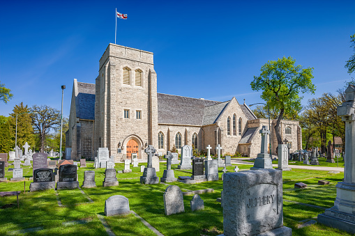 The historic St. Luke's Anglican Church and cemetery in Winnipeg Manitoba Canada on a sunny day