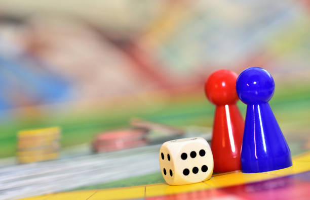 istock Dice, blue, red figures and chips in background on the board. 1269418354