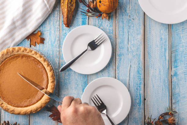 istock Overhead view of a man's hand preparing to cut a pumpkin pie 1269419946