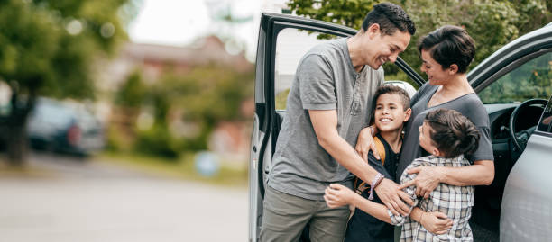 familj med två barn . ögonblick med kramar nära bil - bilförsäkring bildbanksfoton och bilder
