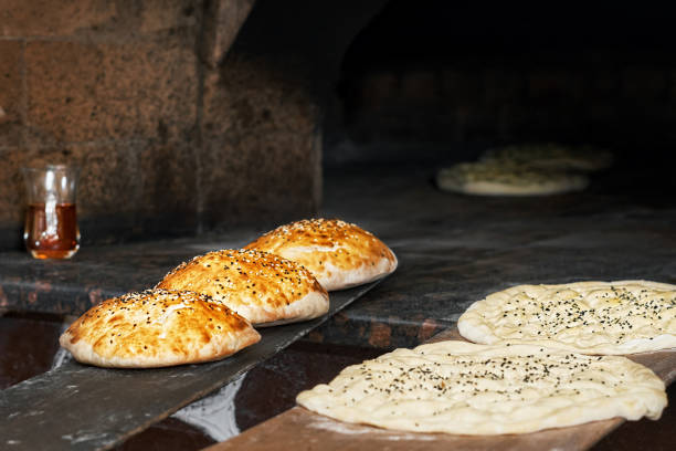 istock Tombik buns and Turkish Ramazan Pide bread before baking. Bread prepared for baking is in front of the stove. Morning pastries. Close-up, copy space, traditional cuisine 1269439409