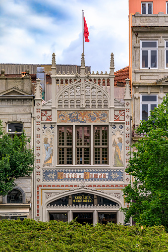 Porto, Portugal - May 30, 2018: Facade of the famous Livraria Lello historic book store decorated with ornate Portuguese azulejo tile mosaic. Inscription says Lello and brother - Book store Chardron