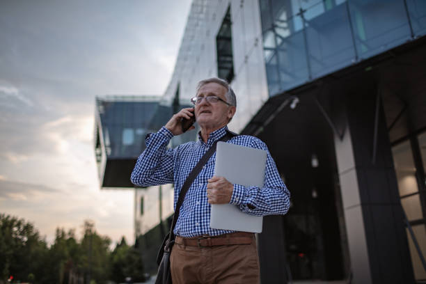 istock Senior business man talking on mobile phone in front the office 1269444778