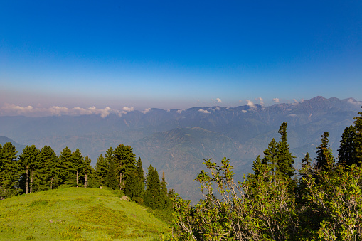 early morning on green hilltop meadows in the summer season with sunrise - Mountains range and siri paye meadows