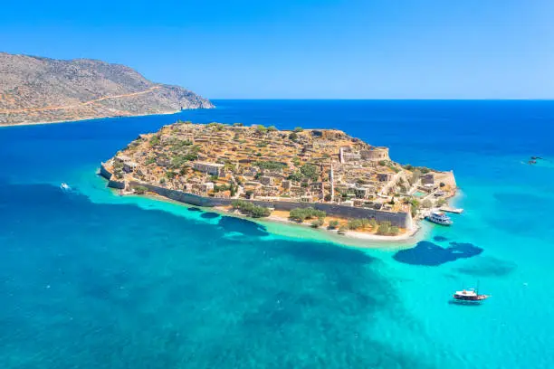 View of the island of Spinalonga with calm sea. Here were isolated lepers, humans with the Hansen's desease, gulf of Elounda, Crete, Greece.