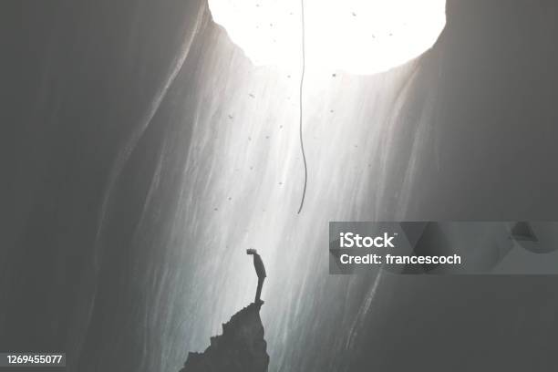Man Finding A Way To Get Out Of Darkness Help From The Sky Surreal Concept Stock Photo - Download Image Now