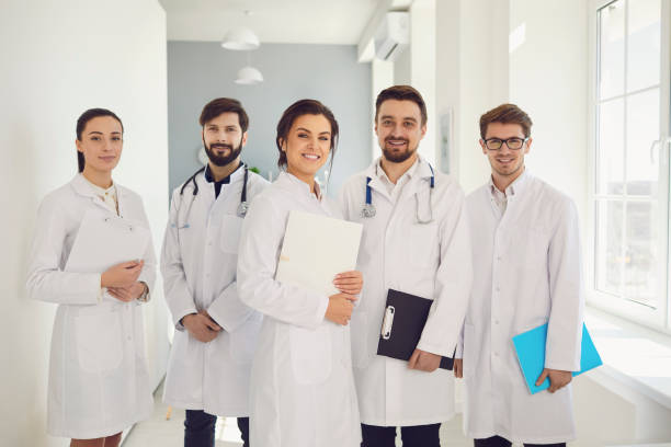 istock A group of confident practicing doctors in white coats are smiling against the backdrop of the clinic. 1269458244