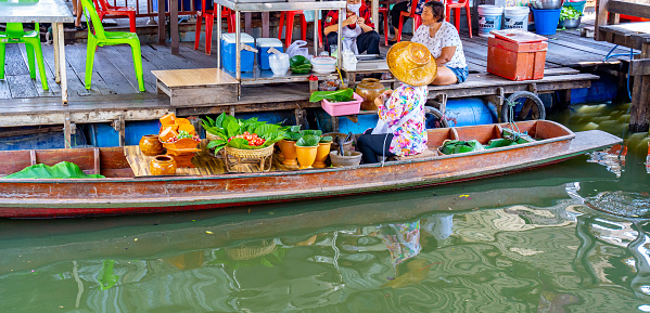 This image shows famous Floating local thai market in bangkok thailand.street market with vendors can be seen in the image.