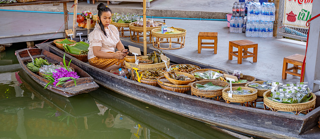 This image shows famous Floating local thai market in bangkok thailand.street market with vendors can be seen in the image.