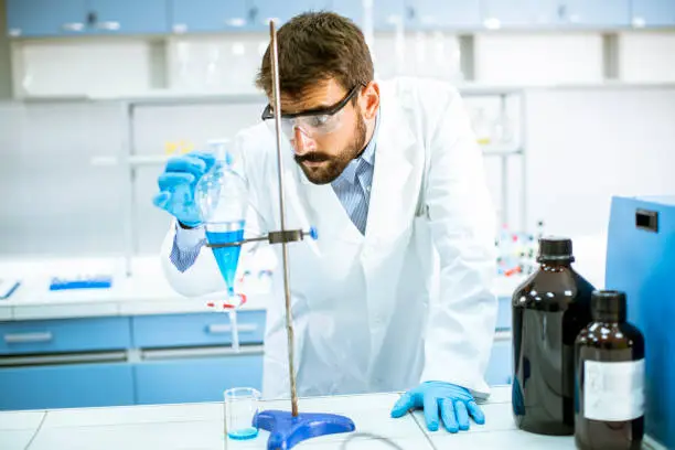 Photo of Researcher working with blue liquid at separatory funnel