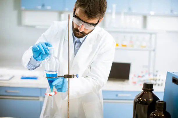 Photo of Researcher working with blue liquid at separatory funnel