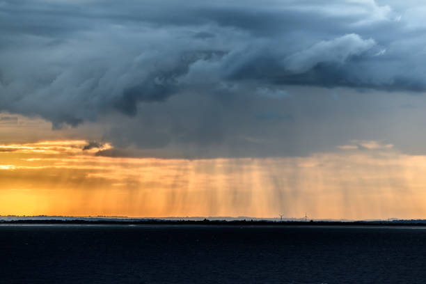 HORNSEA OFFSHORE WIND FARM, UK - 2016 JULY 13. Sunlight and rainy clouds in the horizon at sea.