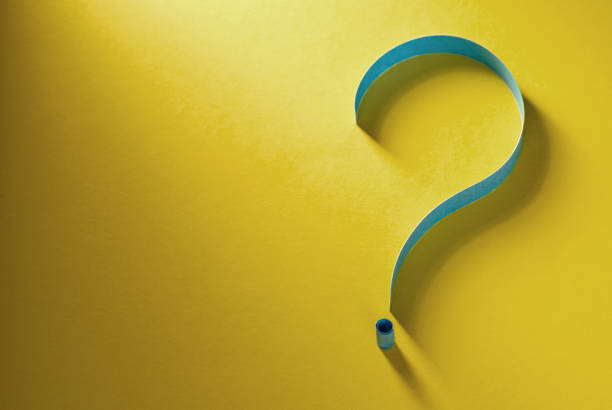 istock Question mark of coiled blue paper on yellow 1269463436