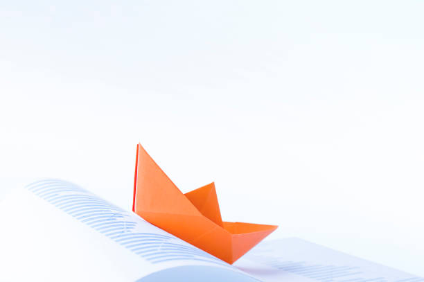 istock one orange paper boat 1269463637