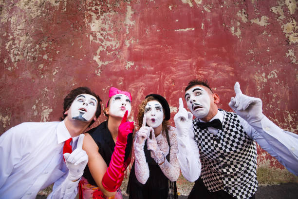 istock Four mimes point to the top on a red wall 1269463795