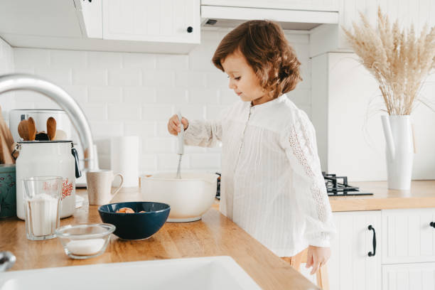 istock Little girl preparing dough for pancakes at the kitchen. 1269468700