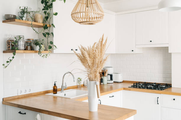 istock Modern white u-shaped kitchen in scandinavian style. Open shelves in the kitchen with plants and jars. 1269468782