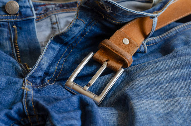 istock Close-up of blue jeans with a brown leather belt. 1269469879