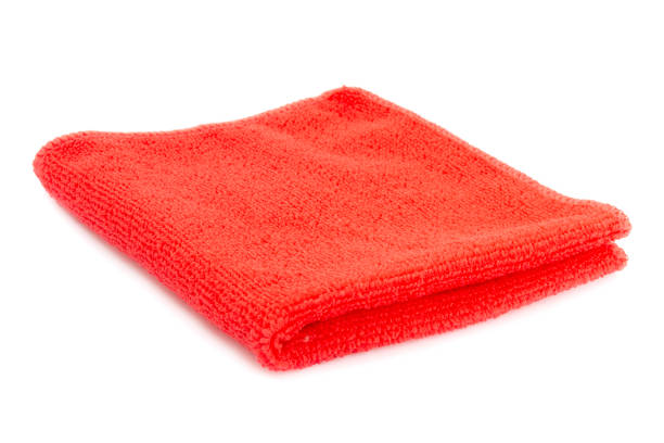 Red beach towel on a white background with shadow. Towel isolated on a white background. Folded beach towel in red. Summer vacation concept.