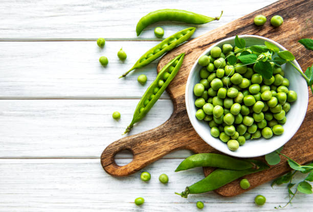 istock Green peas in white bowls 1269474956