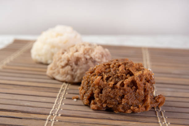 istock Brazilian cocada (coconut candy) placed on a wooden mat on a table with white towel, selective focus. 1269475169