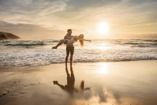 istock Young man picking up her girlfriend at a beach at sunset 1269478491