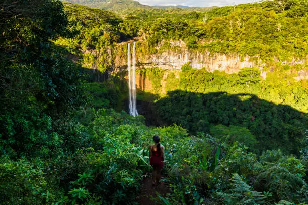 Chamarel waterfall and traveller woman in the tropical jungle of Mauritius