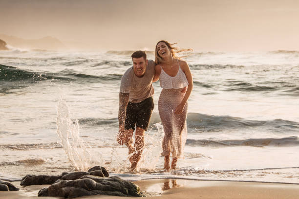 istock Happy young couple walking at a beach at sunset 1269478801