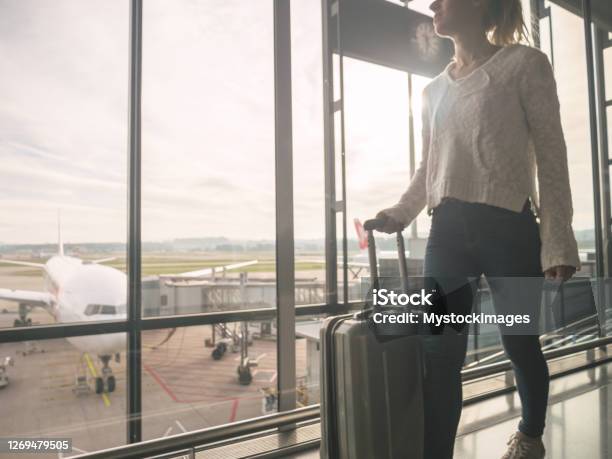 Woman With Hand Luggage Walking In Airport Stock Photo - Download Image Now - Zurich Airport, Airport, Sunrise - Dawn