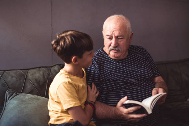 istock Grandfather reading with his grandson 1269481936