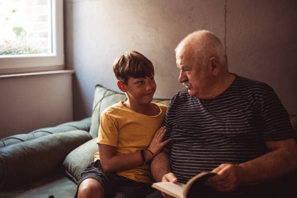 istock Grandfather reading with his grandson 1269481956