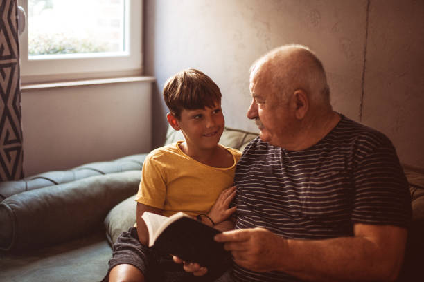 istock Grandfather reading with his grandson 1269481967