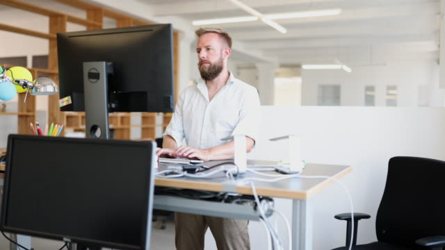 Man working at ergonomic standing desk in office