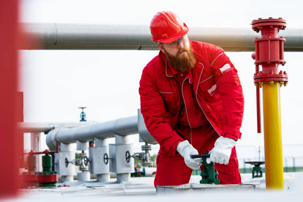 istock Worker adjusting gauge at oil refinery 1269483865