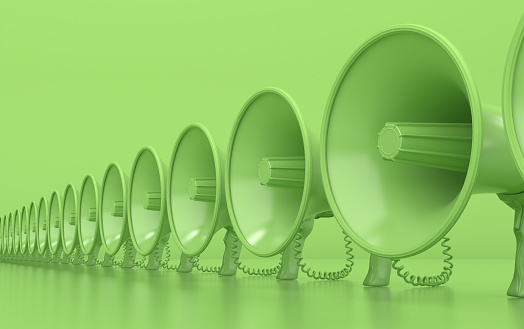 Muchos megáfonos verdes monocromos están en una fila. Altavoces sobre fondo verde. Ilustración conceptual con espacio de copia. Renderizado 3D. photo